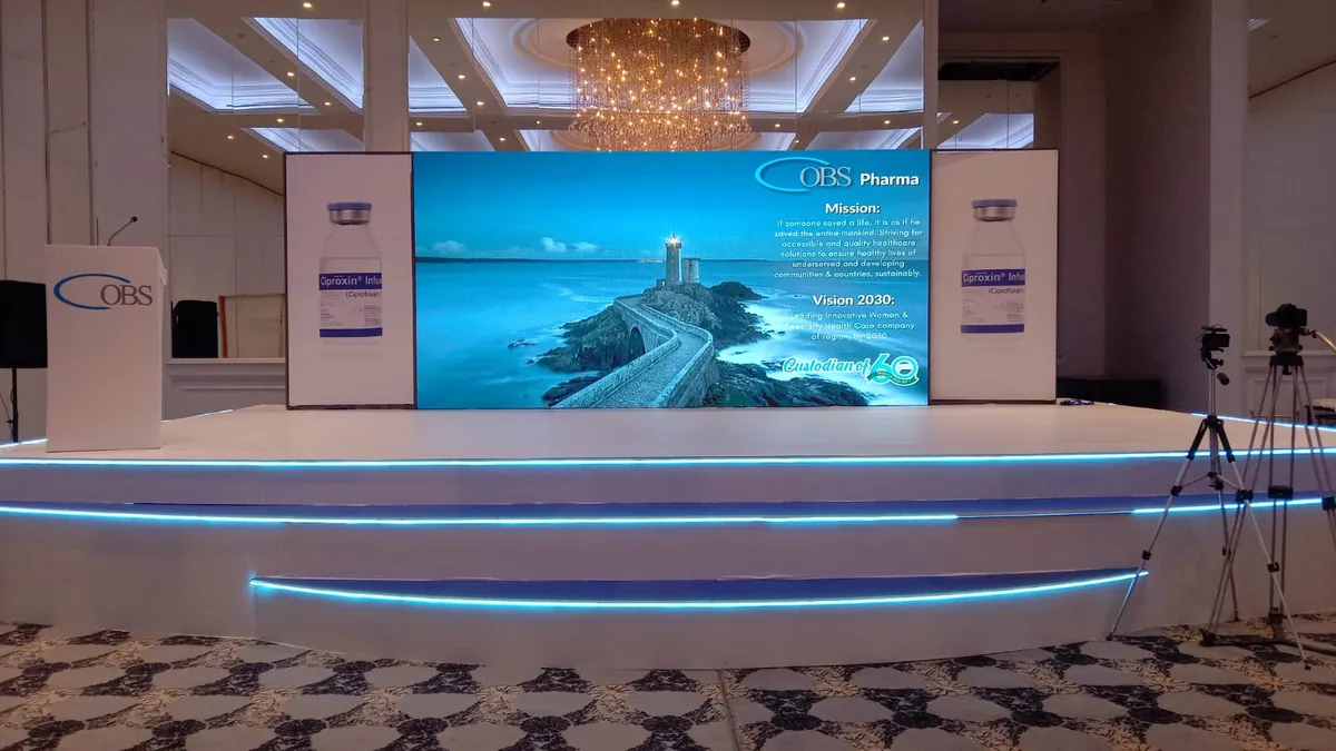 Conference stage with a large LED screen, a branded lectern and a lit stage edge